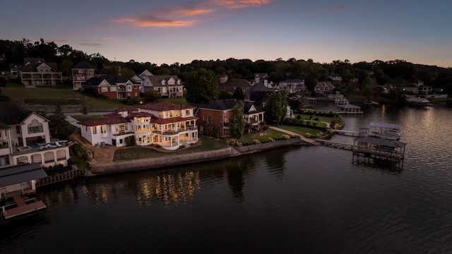 aerial view at dusk featuring a water view