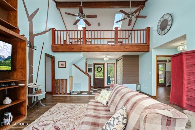 living area with baseboards, beam ceiling, wood finished floors, a ceiling fan, and high vaulted ceiling