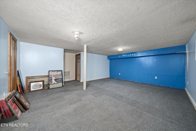 finished basement featuring visible vents, carpet floors, and a textured ceiling