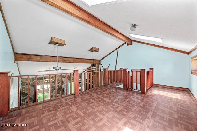 additional living space with vaulted ceiling with skylight, dark parquet flooring, a textured ceiling, and ceiling fan