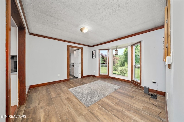 foyer entrance featuring ornamental molding, hardwood / wood-style floors, and a textured ceiling