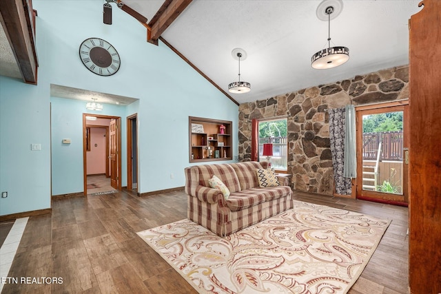 living room with beam ceiling, hardwood / wood-style floors, a textured ceiling, and high vaulted ceiling