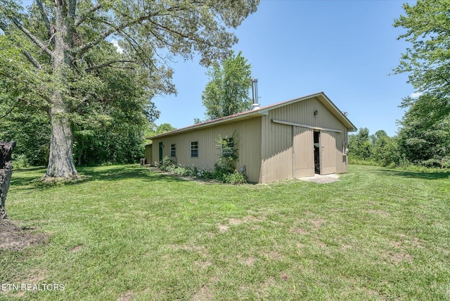 view of home's exterior featuring an outbuilding and a lawn