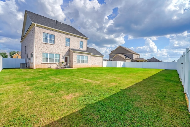 rear view of house featuring a patio, cooling unit, and a yard