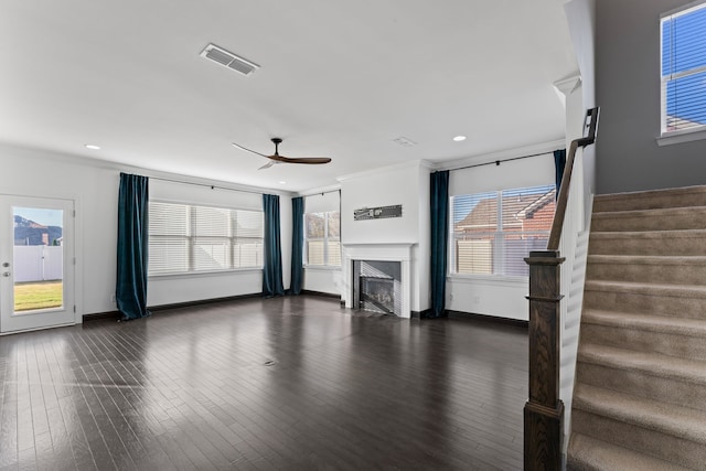 unfurnished living room featuring dark wood-type flooring, crown molding, and ceiling fan