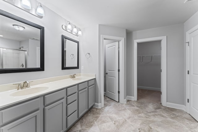 bathroom featuring a shower with door and vanity