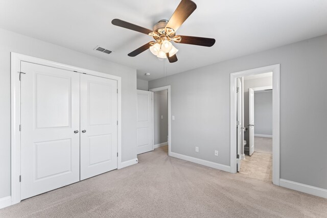 unfurnished bedroom featuring light carpet, a closet, and ceiling fan