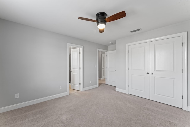 unfurnished bedroom featuring light carpet, a closet, and ceiling fan