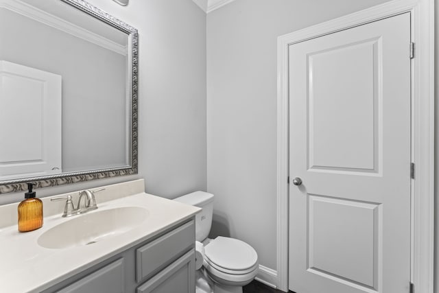 bathroom featuring vanity, ornamental molding, and toilet