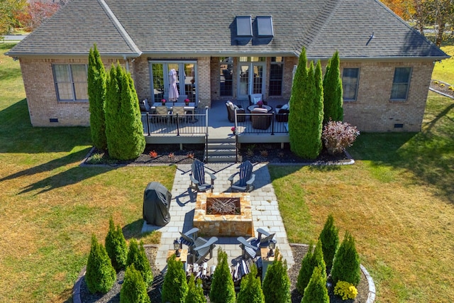 back of house with an outdoor living space with a fire pit, a yard, a deck, and a patio area