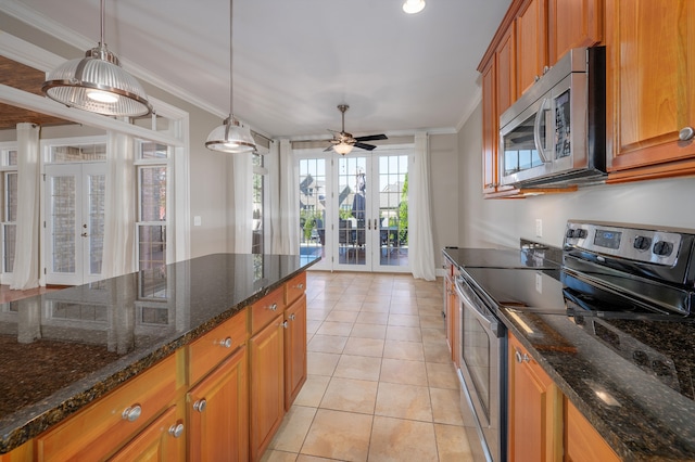 kitchen with french doors, ornamental molding, dark stone countertops, and stainless steel appliances