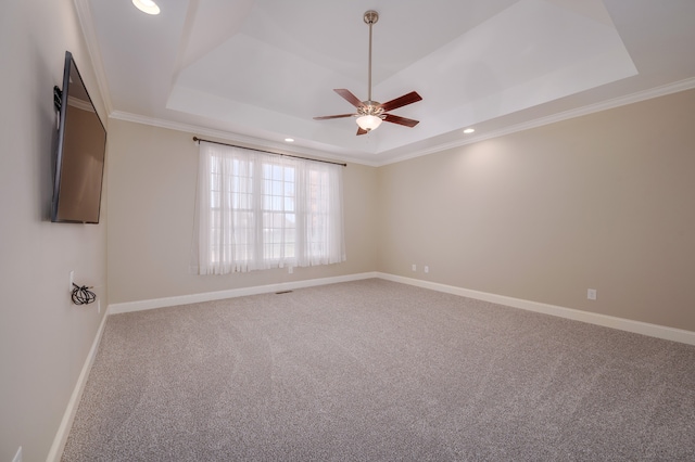 spare room featuring ornamental molding, ceiling fan, carpet flooring, and a raised ceiling