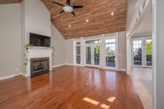 unfurnished living room with ceiling fan, high vaulted ceiling, wooden ceiling, light wood-type flooring, and french doors