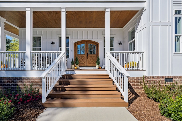 view of exterior entry featuring covered porch