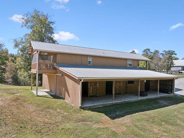 back of house with a yard and an outdoor structure