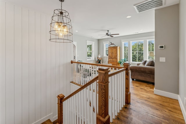 stairway with a notable chandelier and hardwood / wood-style flooring