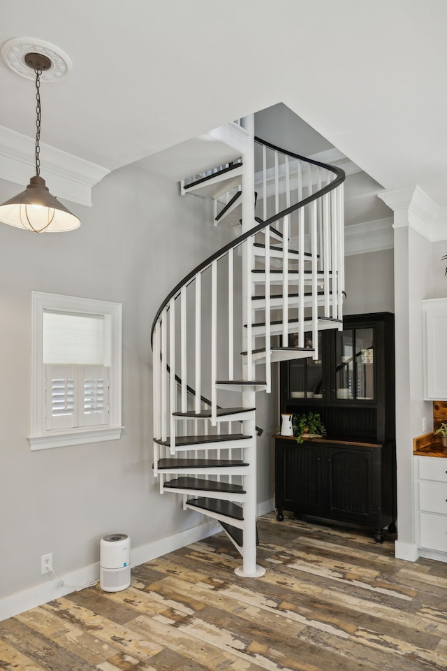 staircase with ornamental molding and hardwood / wood-style flooring