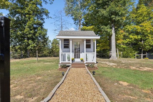 bungalow featuring a front lawn and an outbuilding