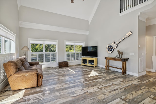 living room with ornamental molding, hardwood / wood-style flooring, high vaulted ceiling, and ceiling fan