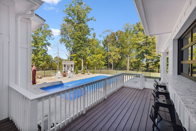 wooden terrace with a patio area and a fenced in pool