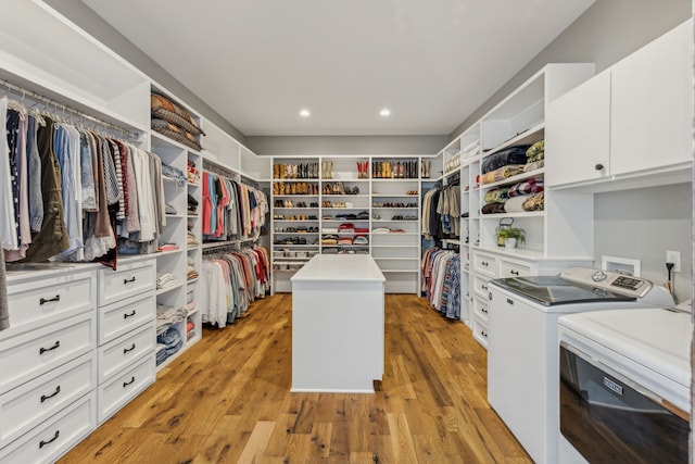 spacious closet featuring light hardwood / wood-style flooring and separate washer and dryer