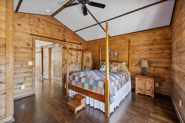 bedroom featuring a barn door, ceiling fan, lofted ceiling, wooden walls, and dark wood-type flooring