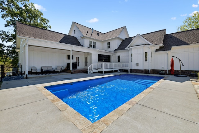 view of swimming pool with a wooden deck and a patio