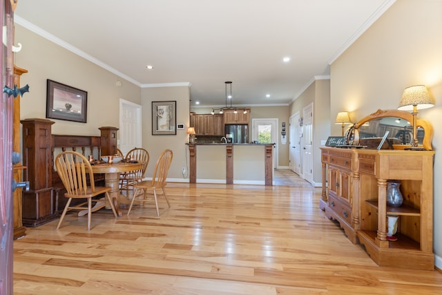 dining space featuring ornamental molding and light wood-type flooring