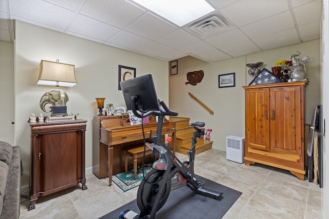 exercise area featuring light tile patterned floors and a drop ceiling