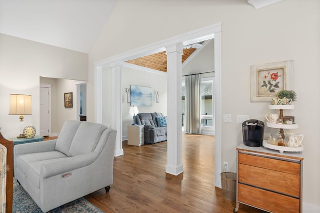 living room with high vaulted ceiling, decorative columns, and dark hardwood / wood-style floors