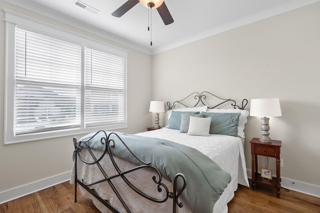 bedroom with ceiling fan, hardwood / wood-style flooring, ornamental molding, and multiple windows