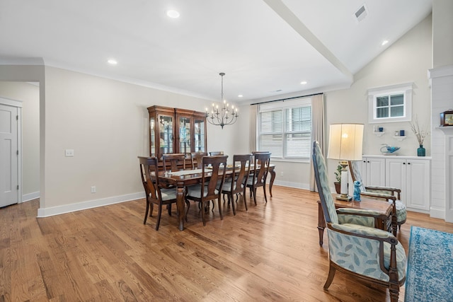 dining space with crown molding, a notable chandelier, lofted ceiling, and light wood-type flooring