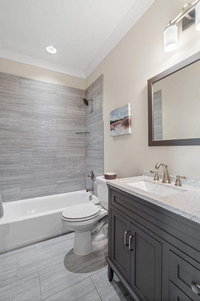 full bathroom with tiled shower / bath, vanity, ornamental molding, and toilet