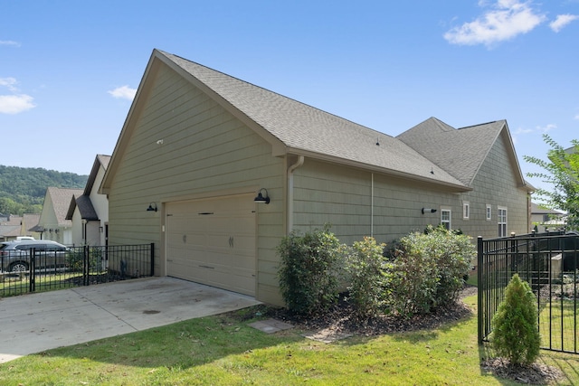 view of side of property with a garage and a lawn