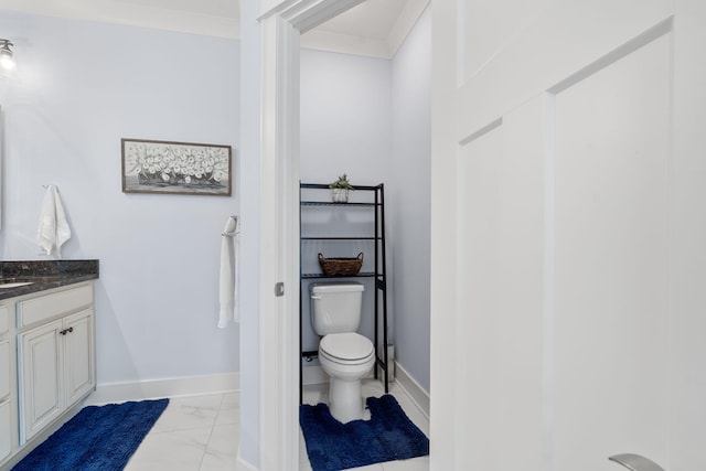 bathroom with vanity, toilet, and ornamental molding