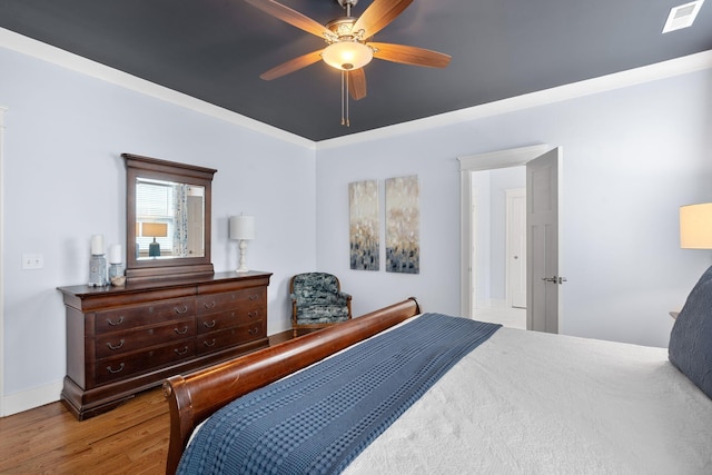 bedroom with ceiling fan, crown molding, and light hardwood / wood-style flooring