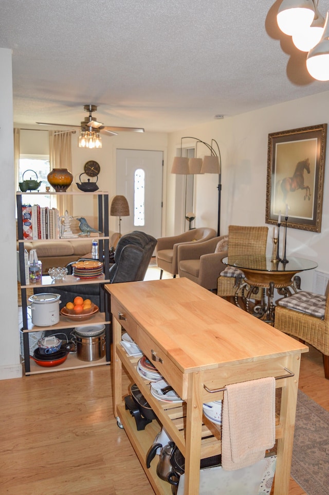 dining area featuring light hardwood / wood-style flooring, a textured ceiling, and ceiling fan