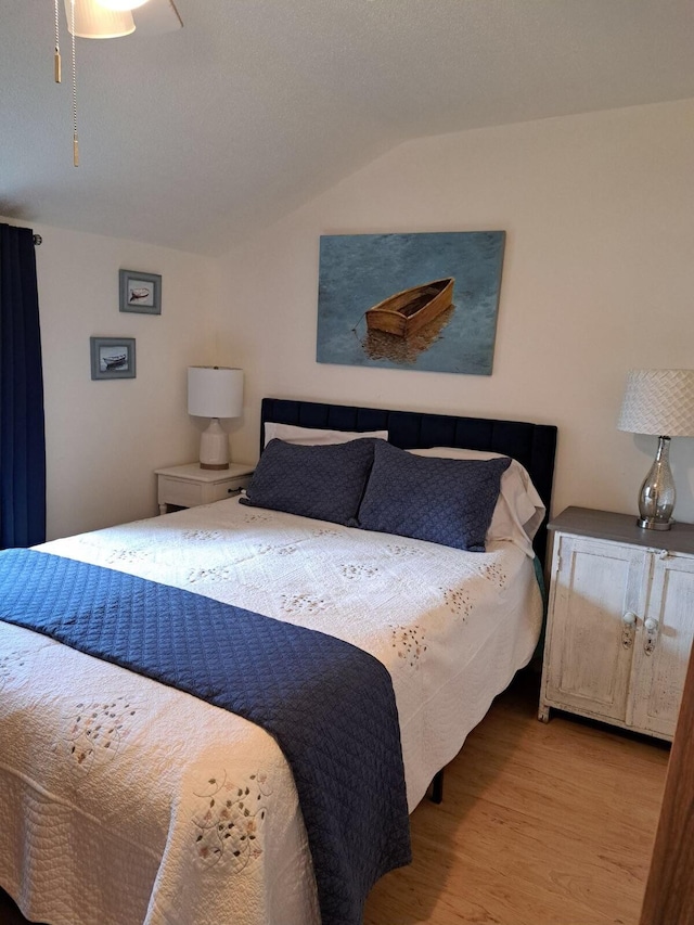 bedroom featuring vaulted ceiling, light wood-type flooring, and ceiling fan