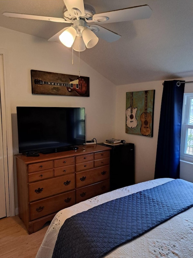 bedroom with lofted ceiling, light hardwood / wood-style flooring, and ceiling fan