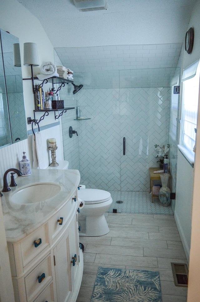 bathroom with vanity, toilet, and a shower with shower door