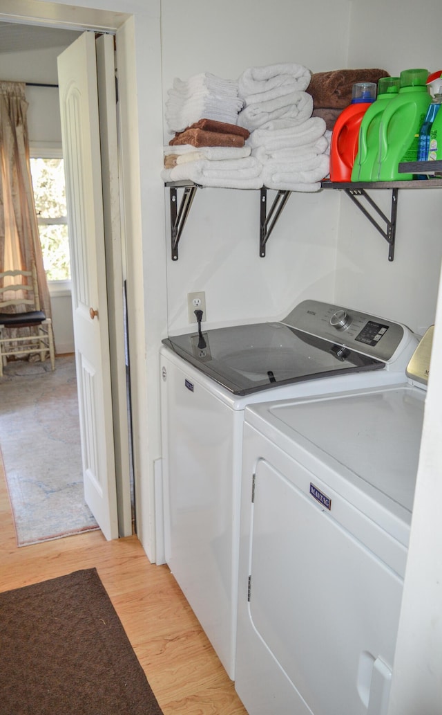 laundry room with independent washer and dryer and light wood-type flooring