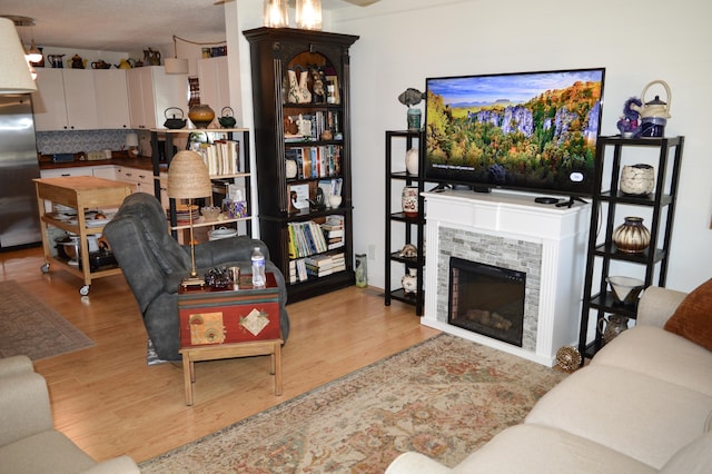 living room with a fireplace and light wood-type flooring