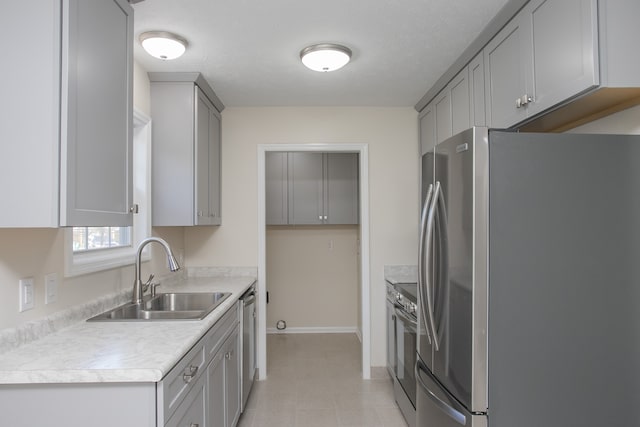 kitchen featuring gray cabinetry, stainless steel appliances, a textured ceiling, and sink