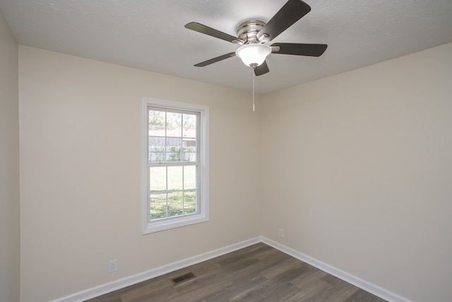 spare room featuring dark hardwood / wood-style floors, a textured ceiling, and ceiling fan