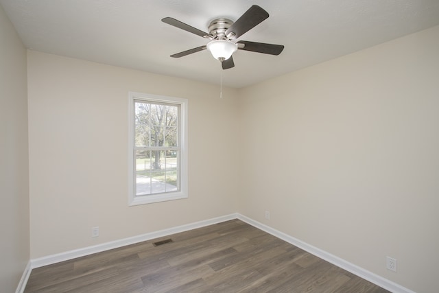 spare room with dark wood-type flooring and ceiling fan