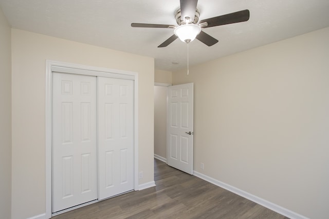 unfurnished bedroom featuring a textured ceiling, dark hardwood / wood-style floors, a closet, and ceiling fan