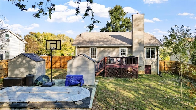 rear view of property featuring a wooden deck, a lawn, and a storage unit