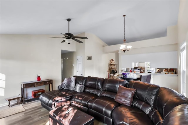 living room featuring lofted ceiling, hardwood / wood-style floors, and ceiling fan with notable chandelier