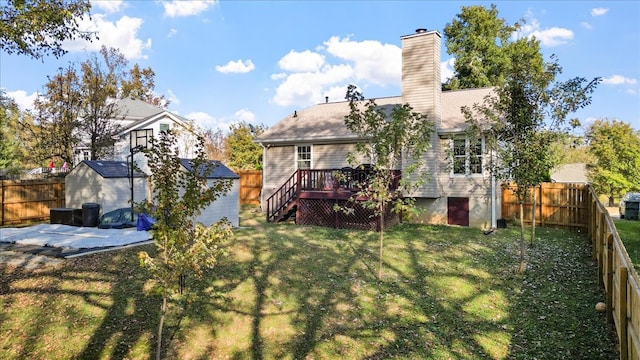 back of property featuring a shed, a wooden deck, and a yard