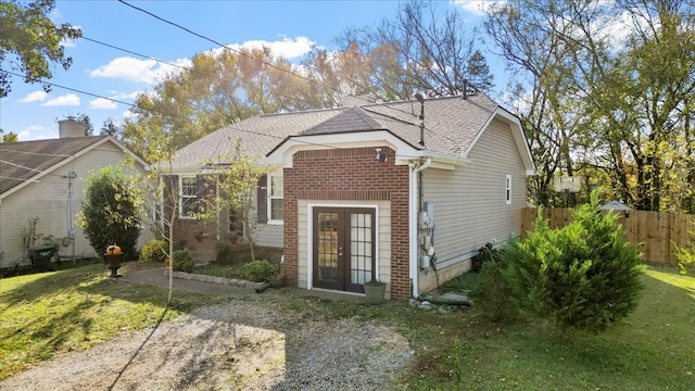 view of front of home with a front yard and french doors